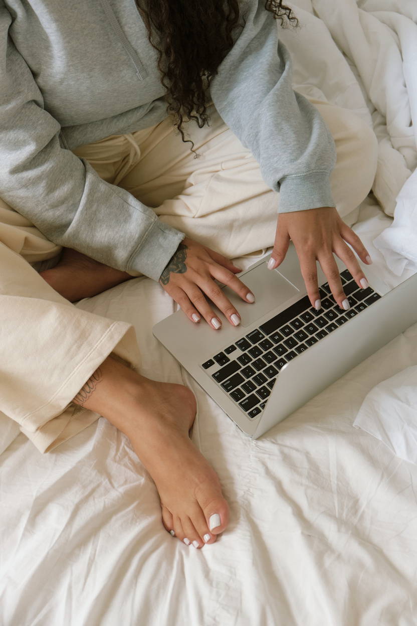 Top View of Woman Working with Laptop on the Bed